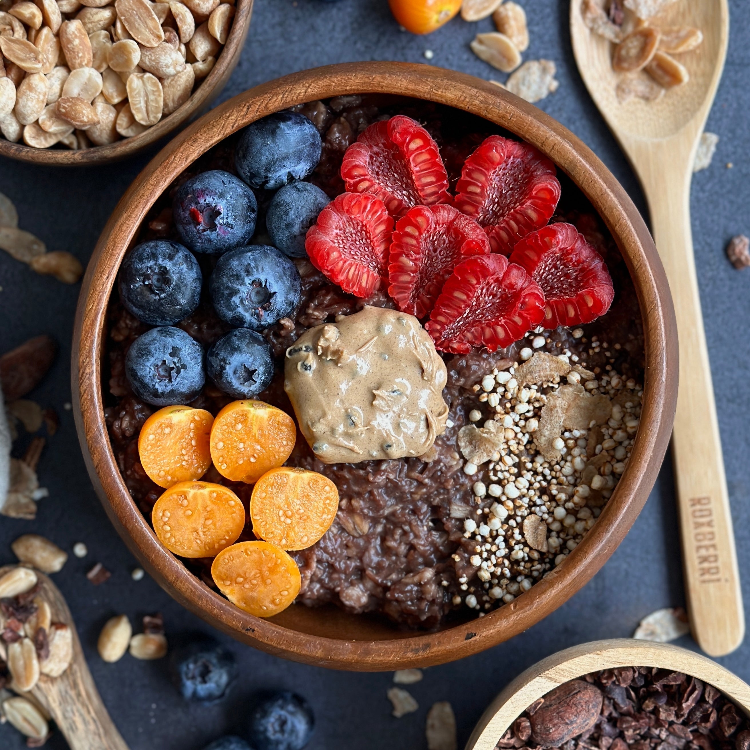 Cremiges Acai Porridge in einer Schüssel mit frischen Beeren und Protein Spread als Topping.