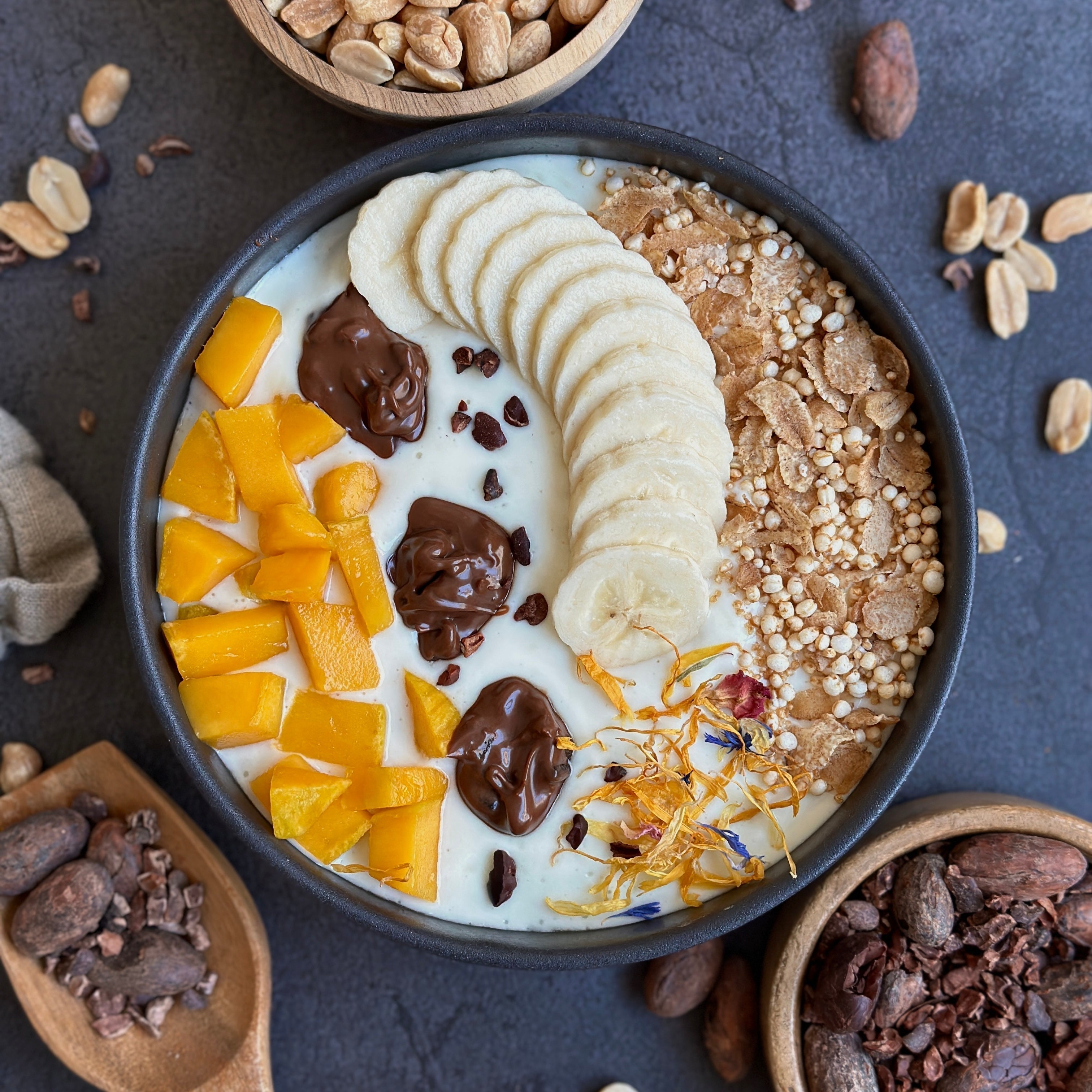 Mango-Schoko Protein-Bowl mit frischen Mangostücken und cremigem Schoko-Spread als Topping in einer Schüssel angerichtet.