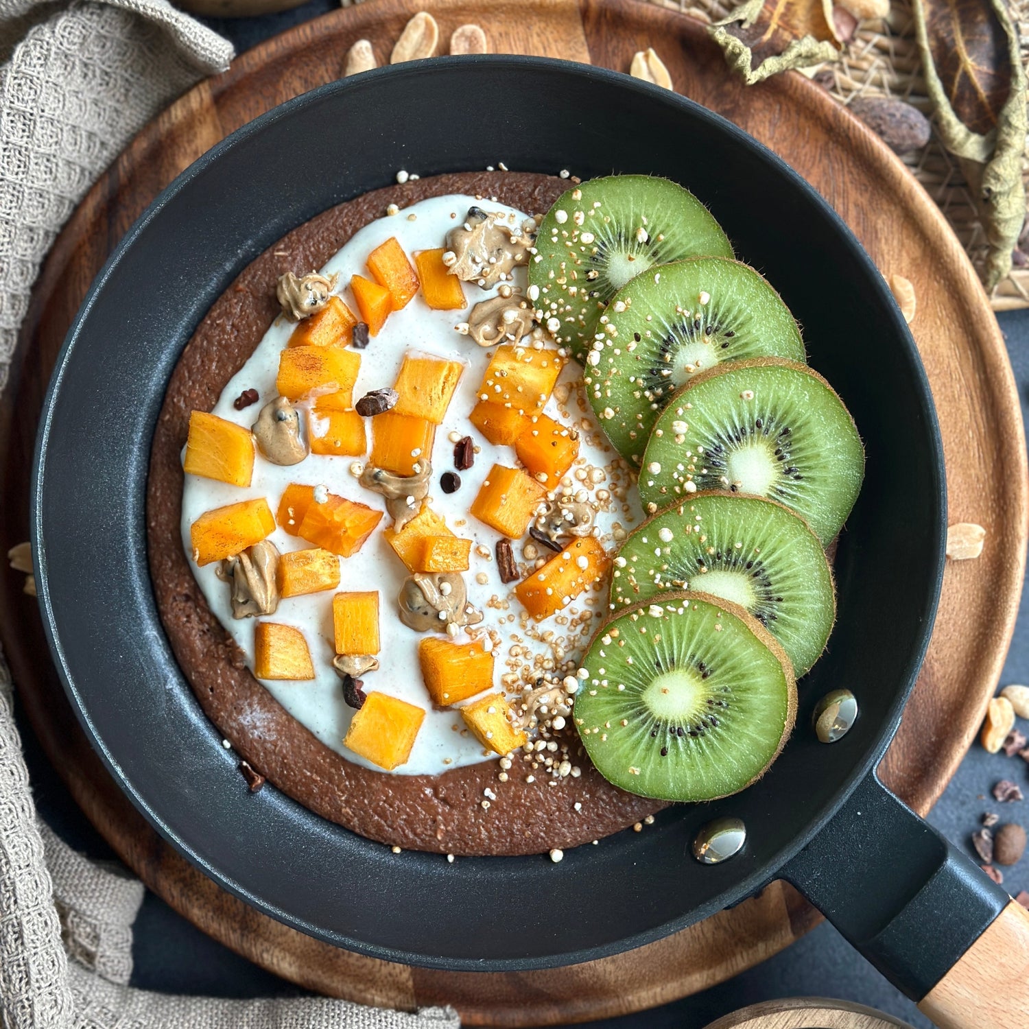 Schoko Cookie Dough in der Pfanne serviert, getoppt mit schmelzendem Protein-Spread und frischem Obst.