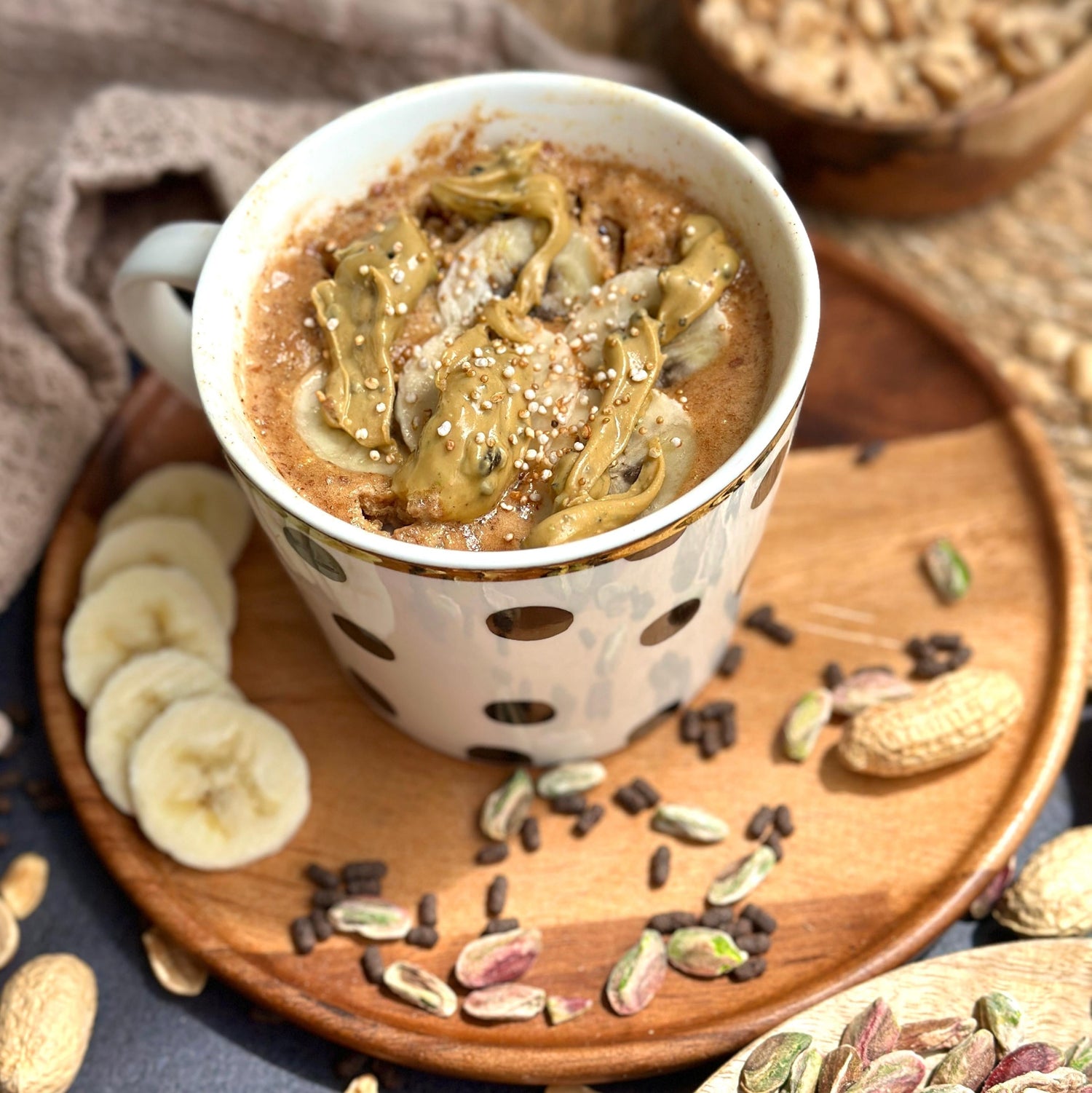Proteinreicher Bananenbrot Tassenkuchen mit cremiger Gain Kitchen Pistaziencreme als Topping, angerichtet in einer Tasse – gesunder, zuckerfreier Snack für schnelle Zubereitung und langanhaltende Energie.