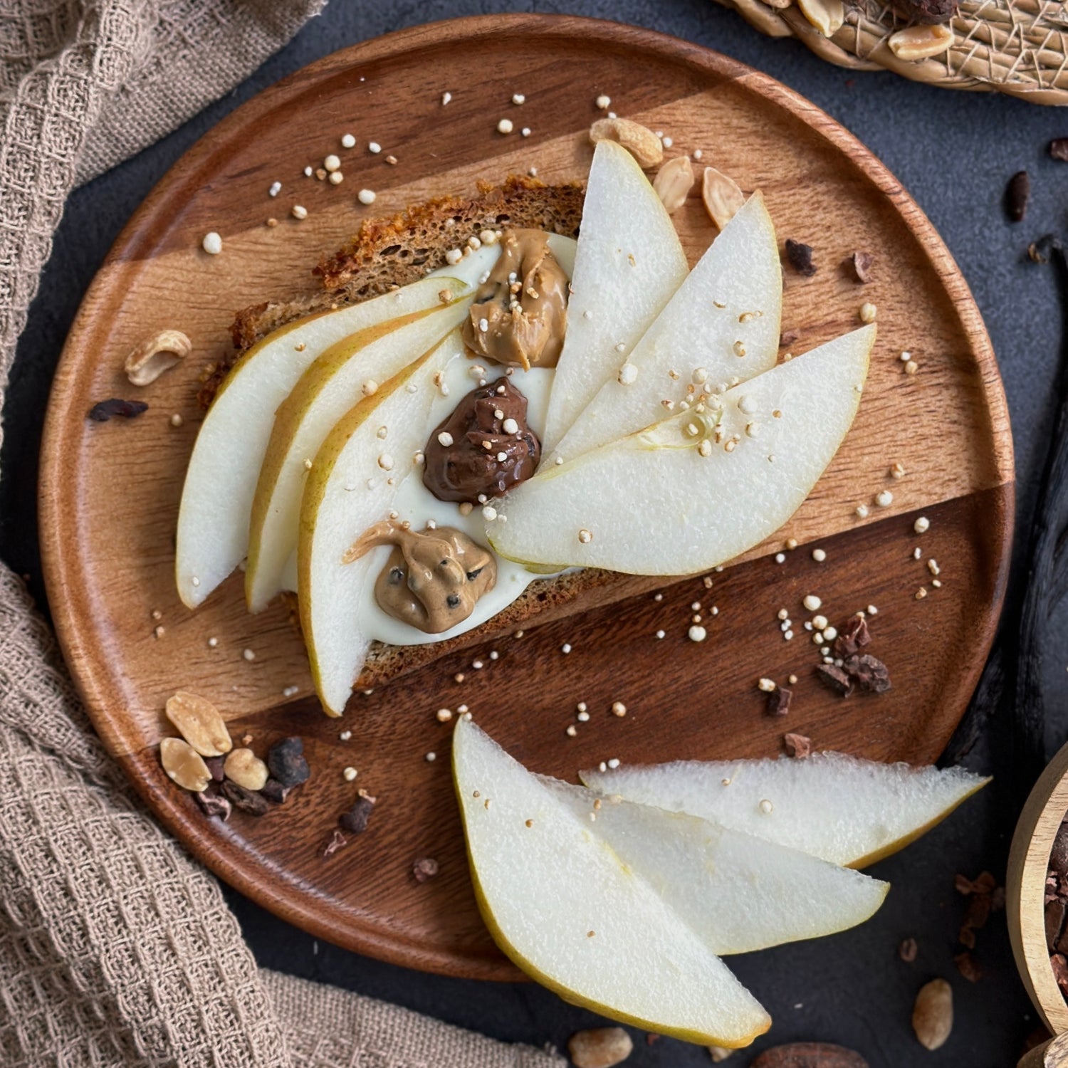 Vollkornbrot mit Zimt-Quark-Creme, frischen Birnenscheiben und cremigem Protein Spread als Topping.