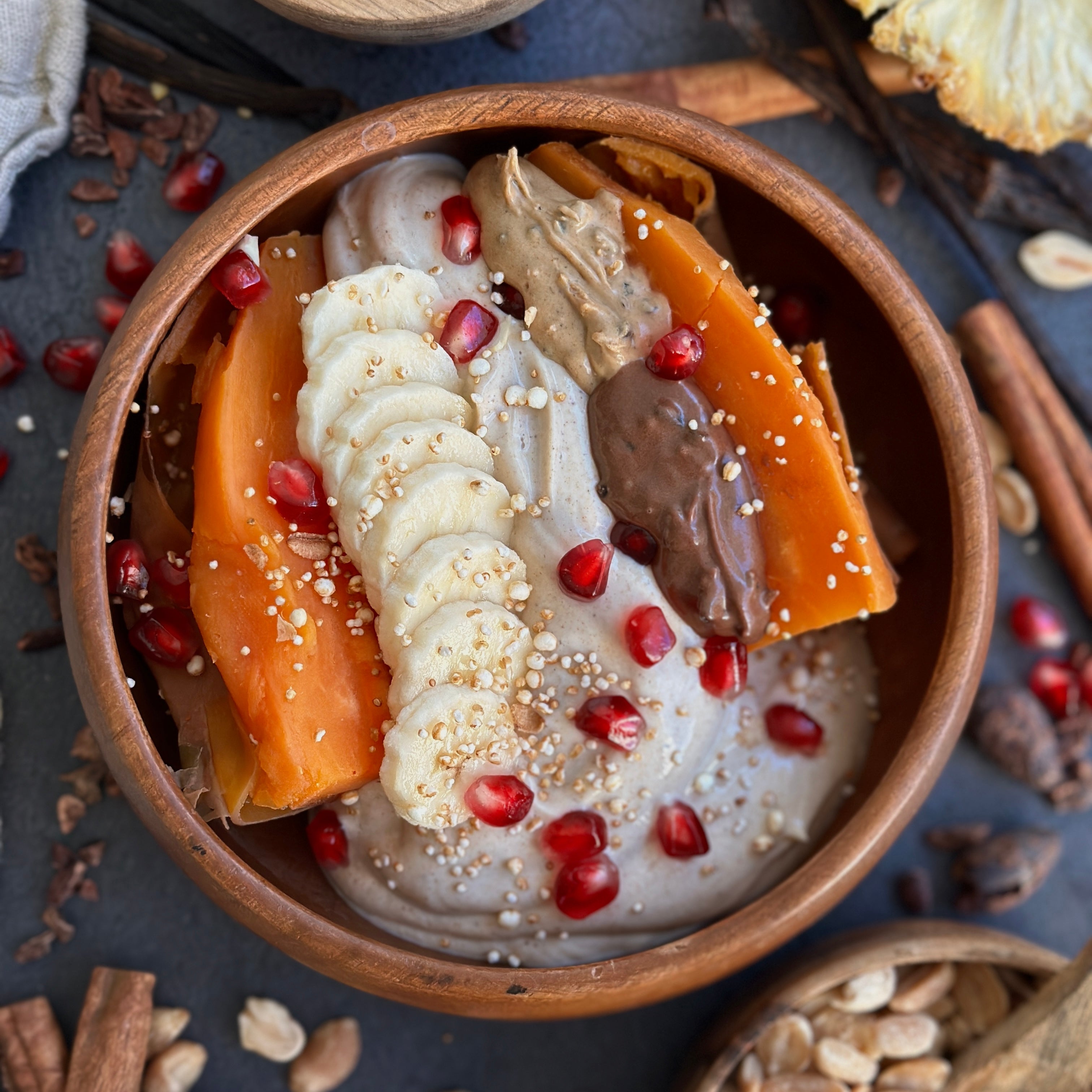 Ofengebackene Süßkartoffel mit cremigem Protein-Dip, Bananenscheiben, Granatapfelkernen und geschmolzenem Protein Spread – gesundes, zuckerfreies Frühstück auf einem Teller