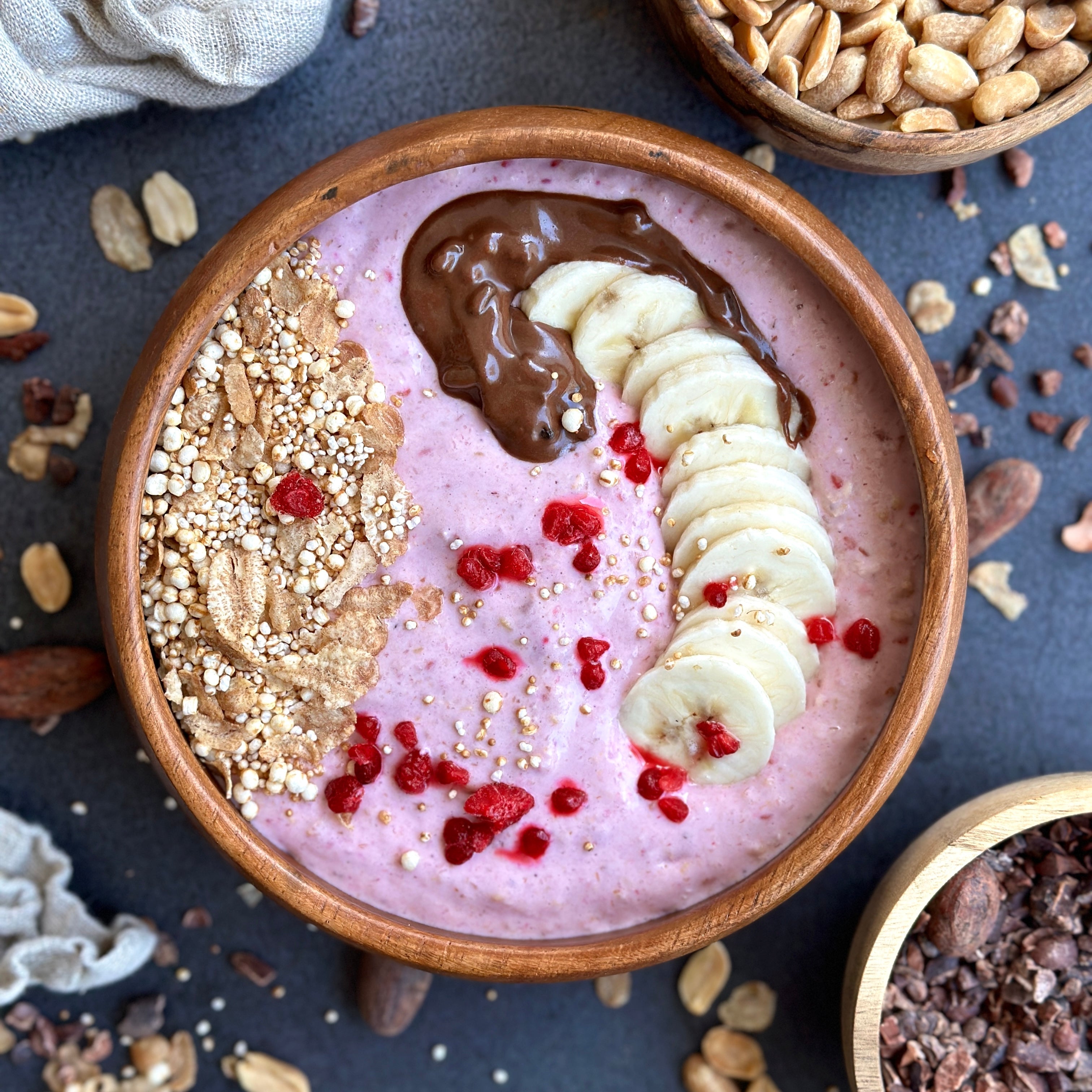 Frische Himbeer-Smoothiebowl mit Protein-Topping und bunten Früchten in einer Schale angerichtet.