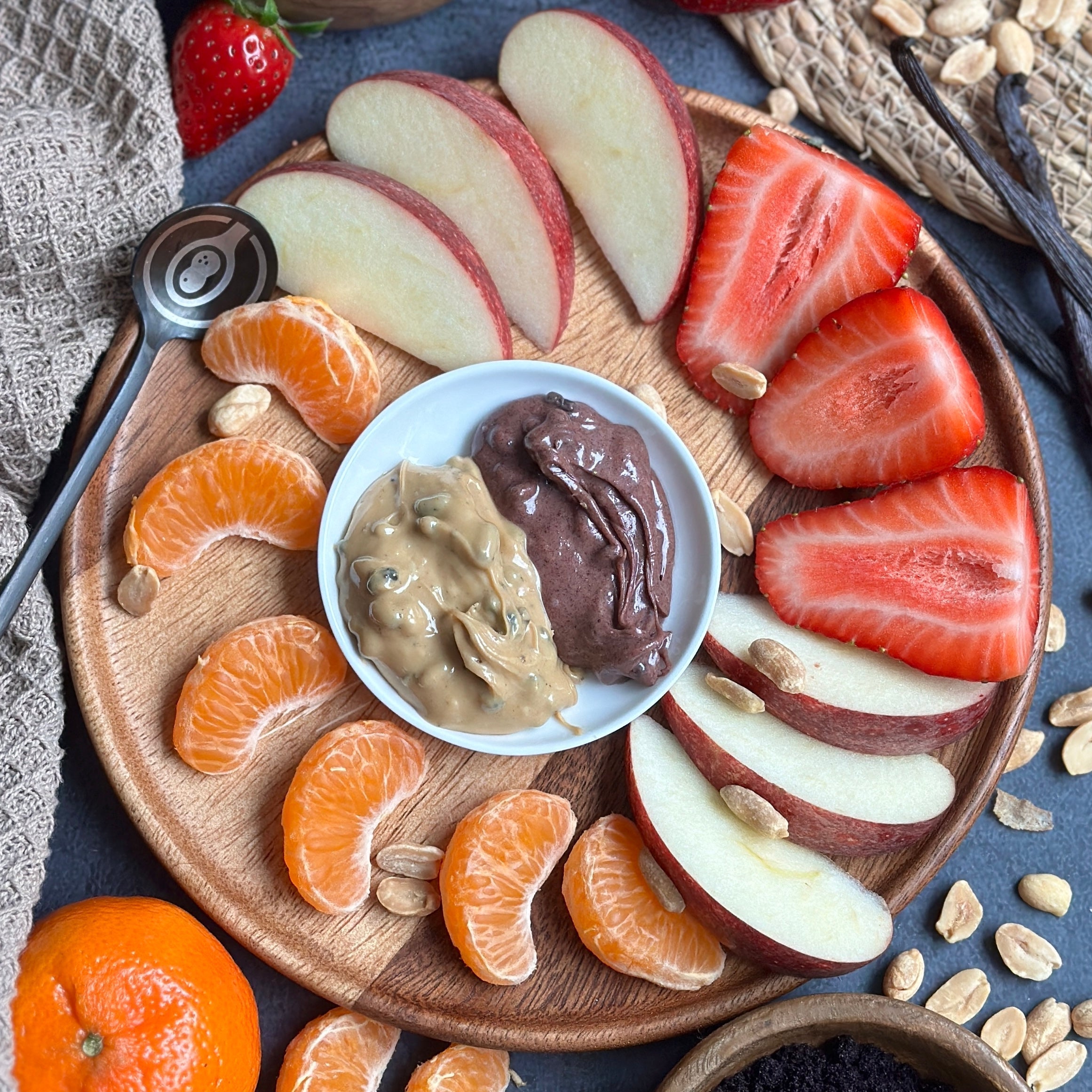 Aufgeschnittenes Obst mit cremigem Protein Spread auf einem Teller angerichtet – perfekter gesunder Snack.