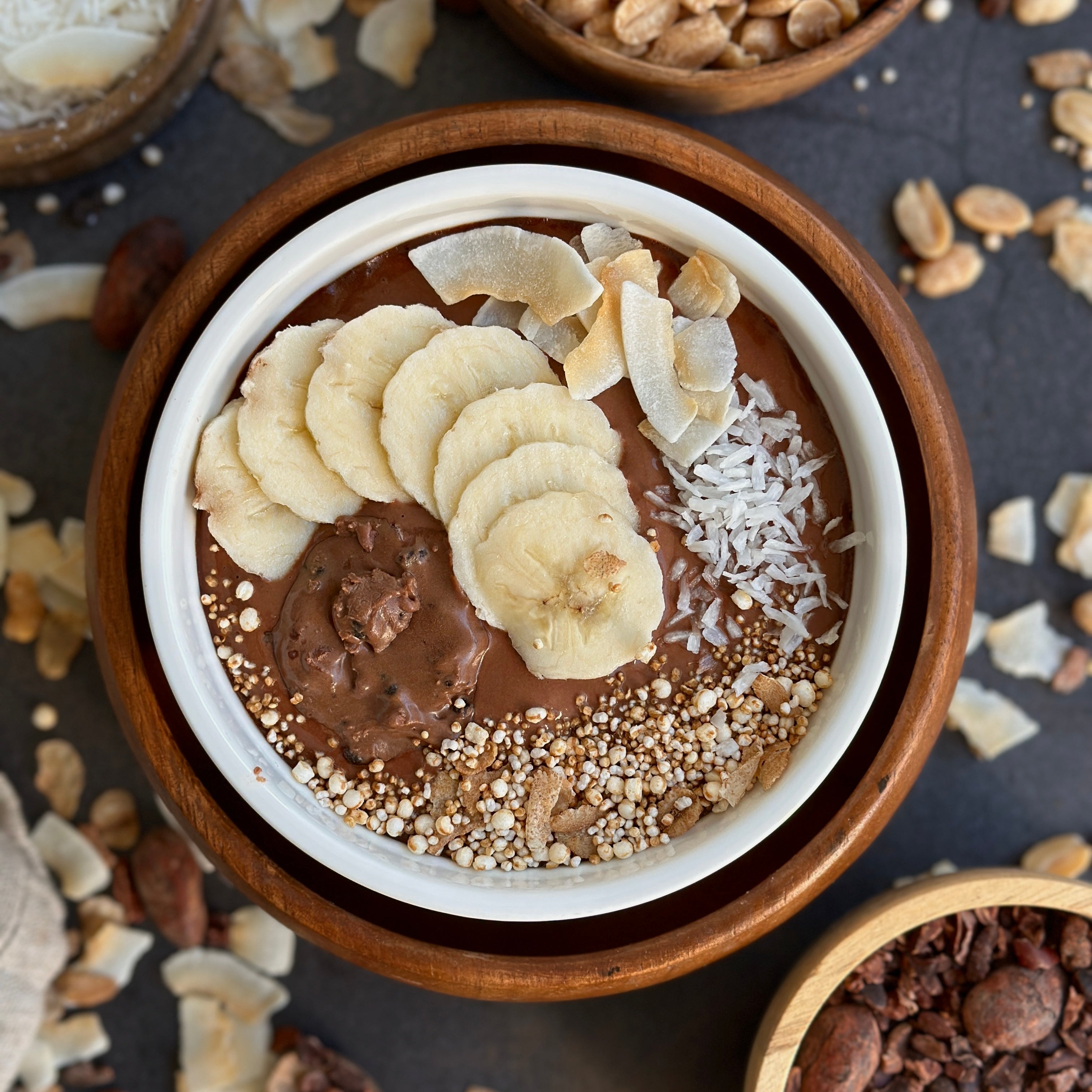 Schoko-Kokos Protein Tassenkuchen in einer Tasse, mit cremigem Schokosoße-Topping und Kokosflakes.